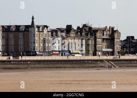 Blick über den Strand auf Gebäude entlang der Promenade in Morecambe Stockfoto