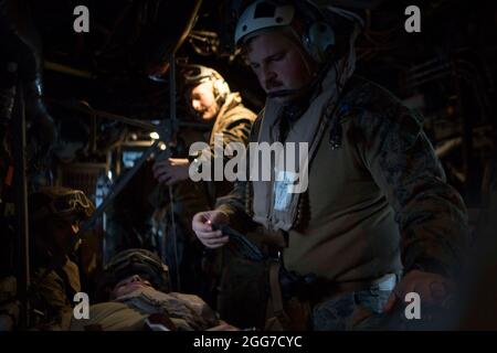 2100405-M-GJ479-204, Atlantischer Ozean, 5. April 2021- Tyler Sack, ein Korpsmann der US-Marine mit 24. Marine Expeditionary Unit (MEU), behandelt einen simulierten Patienten während einer Pflegeübung auf dem Weg an Bord eines luftgetragenen MV-22B Fischadlers über dem Atlantik, 5. April 2021. 24. MEU, die mit der Iwo Jima Amphibious Ready Group gestartet wurde, wird im Einsatzgebiet der 6. US-Flotte zur Unterstützung der nationalen Sicherheitsinteressen der USA in Europa und Afrika eingesetzt. (USA Foto des Marine Corps von Stabsfeldwebel Mark E Morrow Jr/veröffentlicht) Stockfoto