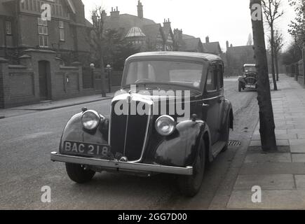 1947, historischer, in einer leeren Vorstadtstraße geparkter Wagen aus der Vorkriegszeit, großer Grundstücke, England, Großbritannien. Interessanterweise befindet sich das Nummernschild auf dem Stoßfänger und nicht darunter. Ein weiteres Auto der Ära steht hinter dem Fahrzeug. Stockfoto