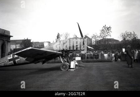 1940s, historisch, Spitfire Fund, lokale Besucher einer Ausstellung eines beschädigten WW2 deutschen Kampfflugzeugs, möglicherweise eines Messerschmitt, in Birmingham, West Midlands, England, Großbritannien will Geld sammeln, um weitere Spitfire-Flugzeuge zu kaufen. Im Vereinigten Königreich wurde erstmals während der Jahre WW1 versucht, Spendenaktionen für Flugzeuge zu sammeln, und so wurde während der Schlacht um Großbritannien ein Spitfire-Fonds eingerichtet, um Mittel für die Kriegsanstrengungen zu sammeln. Die Kosten für einen Spitfire wurden auf nominale £ 5.000 festgelegt und Einzelpersonen, Unternehmen und Gemeinden wurden ermutigt, einen Beitrag zu leisten. Die Stadt Birmingham hatte vier Flugzeuge, die nach ihr benannt wurden. Stockfoto