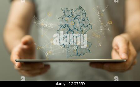 Eine 3D-gerenderte Hologrammkarte von Deutschland über einem Tablet Stockfoto