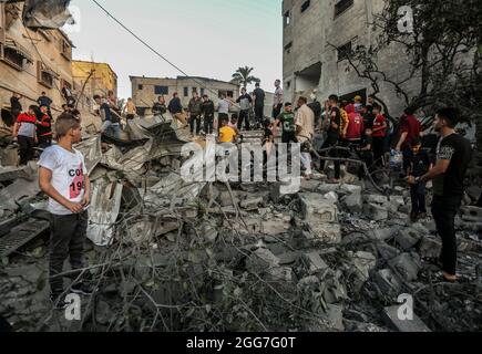 Palästinenser inspizieren beschädigte und zerstörte Häuser, die von israelischen Luftangriffen im südlichen Gazastreifen getroffen wurden, während die Gewalt zwischen Israel und Gaza im Mai 2021 eskaliert. Gaza-Streifen. Stockfoto