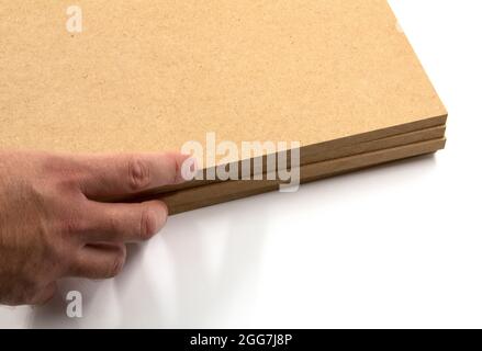 Rohe MDF-Platten, die von Hand auf weißem Hintergrund platziert werden. Stockfoto