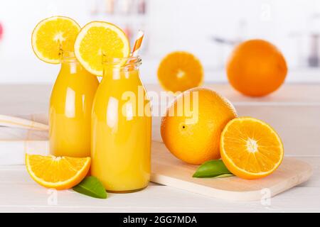 Orangensaft Getränk in der Flasche auf Holzbrett Orangen Stockfoto