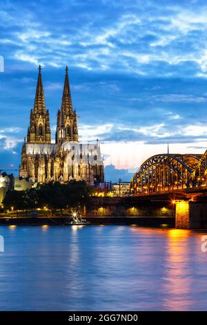 Skyline der Kölner Domstadt und Hohenzollernbrücke mit Rhein in Deutschland bei Dämmerung Porträtformat Nacht Stockfoto