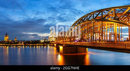 Kölner Dom Skyline und Hohenzollernbrücke mit Rhein in Deutschland bei Dämmerung Panoramablick Nacht Stockfoto