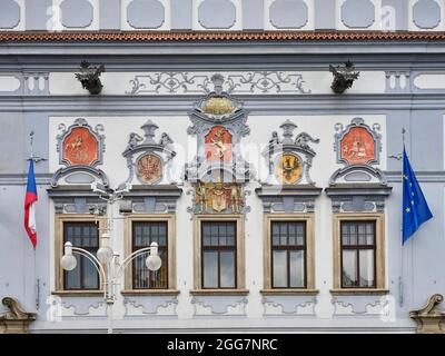 Verzierte historische Gebäudefassade mit verzierten Fenstern und Fahnen in České Budějovice, Tschechische Republik. Stockfoto