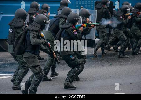 Der thailändische Bereitschaftspolizist feuert während der Demonstration Gummigeschosse auf die Demonstranten ab. Tausende von regierungsfeindlichen Demonstranten fuhren ihre Fahrzeuge und blasse Hörner in einem „Car Mob“-Konvoi, in dem sie den Rücktritt von Prayut Chan-O-Cha, dem Premierminister Thailands, wegen des Scheiterns der Regierung bei der Bewältigung der COVID-19-Krise forderten. An einem Abend an der Kreuzung von DIN Daeng versammelten sich Hunderte regierungsfeindlicher Demonstranten von „Car Mob“ an der Kreuzung von DIN Daeng und kollidierten mit den Polizisten. (Foto von Peerapon Boonyakiat/SOPA Image/Sipa USA) Stockfoto