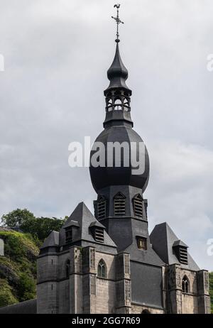 Dinant, Wallonien, Belgien - 8. August 2021: Nahaufnahme der Kirche von Collégiale Notre Dame vor der Wolkenlandschaft mit grünem Laub im Rücken. Stockfoto