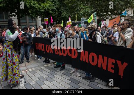 London, Großbritannien. August 2021. Marvina Newton spricht Umweltaktivisten aus dem Extinction Rebellion an, nachdem gefälschtes Blut vor den Büros der Anwaltskanzlei Debevoise & Plimpton LLP während eines Blutgeldmarsches durch die City of London am fünften Tag der Impossible Rebellion-Proteste verbreitet wurde. Extinction Rebellion beabsichtigte, Finanzinstitute, die Projekte mit fossilen Brennstoffen finanzieren, insbesondere im globalen Süden, sowie Anwaltskanzleien und Institutionen, die diese Projekte unterstützen, hervorzuheben und forderte die britische Regierung auf, alle neuen Investitionen in fossile Brennstoffe mit sofortiger Wirkung einzustellen. Kredit: Ma Stockfoto