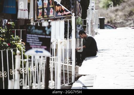 ZACATECAS, MEXIKO - 01. Apr 2018: Ein hispanischer Mann sitzt auf den Straßen von Zacatecas in Mexiko Stockfoto