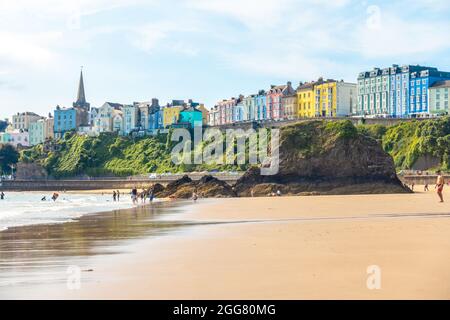 Ein Blick entlang des North brach bei Tenby in Wales mit bunten Gebäuden im Zentrum von Tenby im Hintergrund. Stockfoto