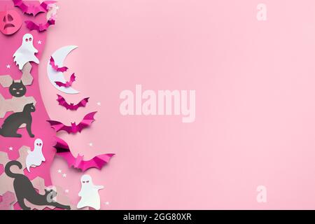 Niedliche Halloween-Bordüre mit Kopierraum. Schwarze Katzen, leuchtend violette Papierfledermäuse, rosa Kürbisse, lustige weiße Geister. Flach auf rosa und lila Papier mit Witz legen Stockfoto