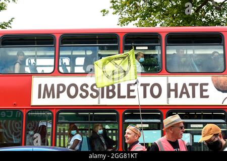 London, Großbritannien. August 2021. Die Protestierenden der Extinction Rebellion marschieren an einem Bus vorbei mit einer Anzeige, die während des Protestes ‘Impossible to hate' sagte.XR Unify ist eine BIPOC-geführte (schwarze, indigene und farbige) Gruppe, die Maßnahmen ergreift, um die fossile Energiewirtschaft zu stoppen. (Foto von Dave Rushen/SOPA Images/Sipa USA) Quelle: SIPA USA/Alamy Live News Stockfoto