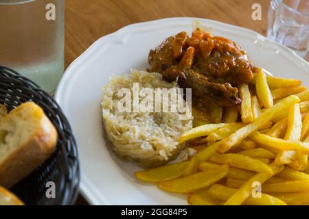 Bratkartoffeln, Sauerkraut, geschmortes Huhn Stockfoto