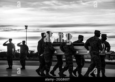 Ein US Air Force Carry-Team trägt während der nächtlichen Schulung des Air Force Mortuary Affairs Operations am Dover Air Force Base, Delaware, 30. März 2021, einen Fall für den Transfer von Trainingseinheiten. Die während des Trainings verwendeten Transferfälle werden gewichtet, um einen gefallenen Servicemitglied mit voller Schutzausrüstung zu simulieren. (USA Luftwaffe Foto von Airman 1st Class Stephani Barge) Stockfoto