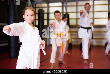 Mädchen kämpfen Karate stehen in der Turnhalle. Kinder zu zweit üben Karate Stockfoto