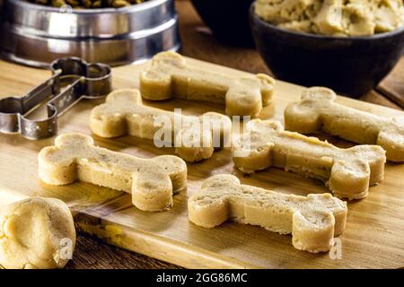 Hundefutterteig in Form eines knochenförmigen, rohen Teiges, der zu Hause gekocht wird Stockfoto