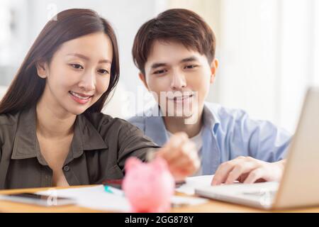 Glückliches Paar, das Münze in piggybank.Home Budget.Family Finanzen. Stockfoto