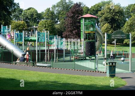Teil des Kinderspielparks im Pittencrieff Park, Dunfermline mit Kindern und Erwachsenen. Über dem Eingangstor: 'Alles ist gut, da alles bette wächst Stockfoto