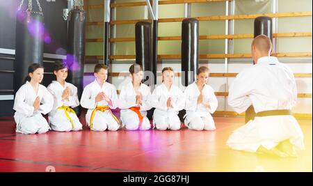 Kinder mit einem männlichen Lehrer, der in der Karate-Klasse posiert Stockfoto