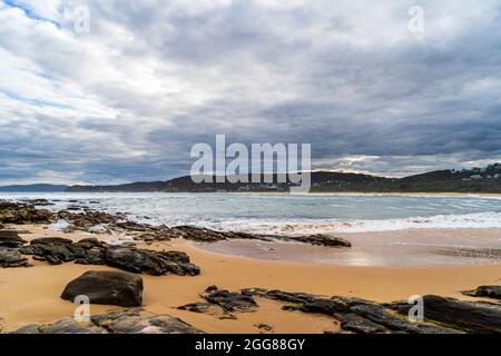 Putty Beach, Central Coast, NSW, Australien an einem wilden stürmischen Tag mit Felsen im Vordergrund Stockfoto