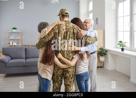 Eine glückliche Familie umarmte ihren altgedienten Vater, der vom Militär nach Hause zurückgekehrt ist Stockfoto