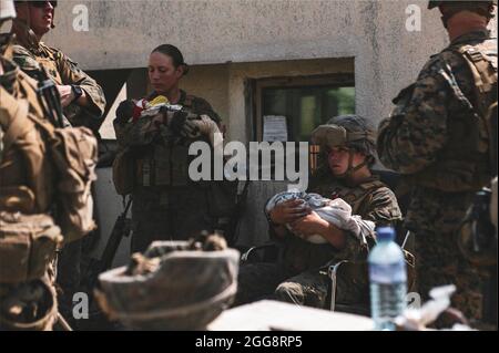 Eine Frau, die als United States Marine Corps Sergeant Nicole Gee aus Roseville, Calif identifiziert wurde, steht links, während sie und andere Militärdienstmitarbeiter Säuglinge auf dem Hamid Karzai International Airport in Kabul, Afghanistan, trösten, auf einem Foto, das am 20. August 2021 auf Twitter veröffentlicht wurde. Sgt. Gee gehörte zu den 13 US-Dienstmitgliedern, die bei einem Terroranschlag getötet wurden. Foto vom Verteidigungsministerium über CNP/ABACAPRESS.COM Stockfoto