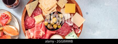 Panorama aus Wurstwaren und Käse mit Rotwein und Oliven, von oben mit Kopierfläche aufgenommen. Spanische Tapas oder italienische Antipasti. Lachs-Sandwiches Stockfoto