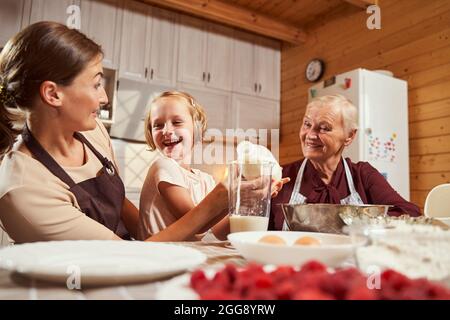 Ältere Frau und Frau mit Spaß mit Mädchen beim Kochen Stockfoto