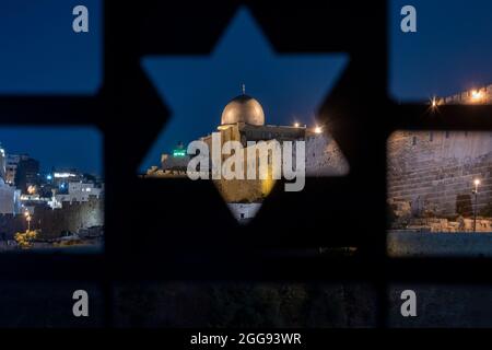 Blick auf den islamischen Schrein der Al-Aksa-Moschee über einen Zaun, der mit dem jüdischen Davidstern auf dem alten jüdischen Friedhofsberg der Oliven Ostjerusalem Israel perforiert wurde Stockfoto