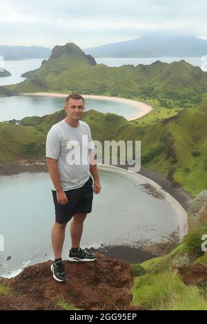 Blick auf einen Mann auf der Spitze der Insel Padar in der Nähe des Komodo-Nationalparks. Stockfoto