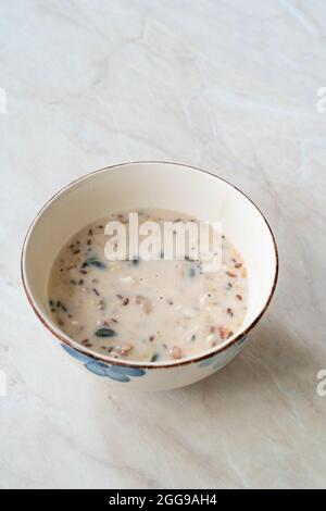 Hausgemachte glutenfreie vegane gerollte Hafer mit Heidelbeeren, Kürbiskernen, Cranberries, Erdbeeren, Sonnenblumensamen und Leinsamen in heißer Mandelmilch für Stockfoto