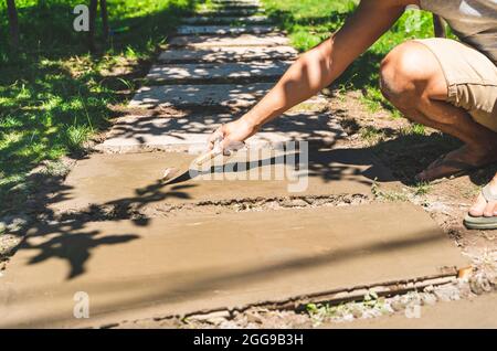 Machen Betonplatten Gehweg auf grünem Gras gesetzt. Stockfoto