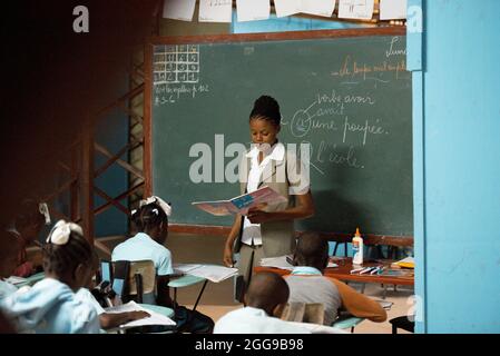 PORT AU PRINCE, HAITI - 02. Jul 2017: Eine schwarze Lehrerin unterrichtet haitianische Schulkinder an einer Schule in der Stadt Port-au-Prince, Haiti Stockfoto