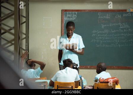 PORT AU PRINCE, HAITI - 02. Jul 2017: Ein junger schwarzer Junge liest vor seinen Klassenkameraden an einer Schule in Haiti Stockfoto