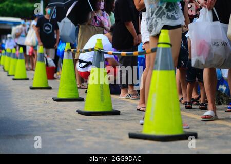 Keelung, Taipei, Taiwan. August 2021. Strandgänger stehen an einem Strand in Keelung an, wo die Menschenmenge kontrolliert wird, da Taiwan laut dem taiwanesischen CDC nur 3 lokal erworbene Fälle und null Todesfälle meldet. Nachdem die Versammlungen und Schwimmaktivitäten wieder aufgenommen wurden, verzeichnet die selbstregierte Insel seit ihrem schweren Ausbruch im Mai einen Abwärtstrend bei einheimischen Covid-Infektionen und -Todesfällen, indem sie Impfstoffe für AstraZeneca, Medigen und Moderna zur Verfügung stellt, während sie Impfstoffspenden aus den USA, Japan, Litauen und der Tschechischen Republik erhält. Angesichts der zunehmenden militärischen Bedrohungen Chinas. (Bild: © Dani Stockfoto