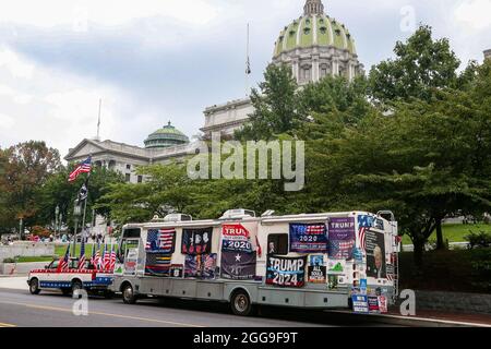 Ein Freizeitfahrzeug (RV), das mit pro-Trump-Schilder bedeckt ist, die während der Anti-Impfstoff-Kundgebung für Freiheit in der Nähe des Pennsylvania State Capitol geparkt wurden. Anti-Impfstoff-Demonstranten versammelten sich auf den Stufen des Pennsylvania State Capitol während der Kundgebung für Freiheit. Die weltweite Kundgebung für Freiheit 3.5 im Pennsylvania State Capitol war eine von vielen koordinierten Veranstaltungen in den Vereinigten Staaten, die ein Ende der Impfmandate forderten. Stockfoto