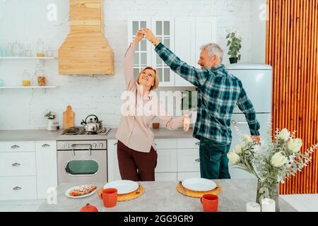 Mann und Frau tanzen zu Hause während des Frühstücks Stockfoto