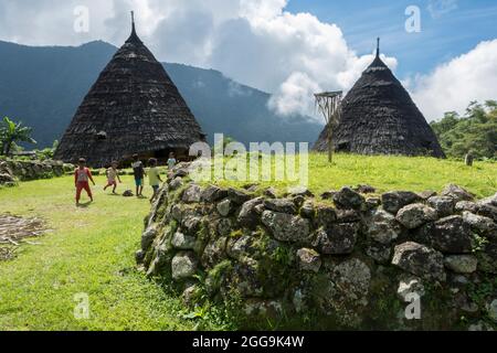 Spielende Kinder in der Nähe des Altars (Compang) des traditionellen Dorfes WAE Rebo in den bewaldeten Bergen von Ost-Nusa Tenggara, Flores, Indonesien Stockfoto