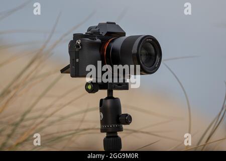 Nahaufnahme einer spiegellosen Kamera auf einem Stativ am Strand Stockfoto