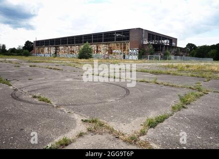 Oranienburg, Deutschland. Juli 2021. Die baufällige Eingangshalle des ehemaligen Flughafens zwischen Oranienburg und Leegebruch. Der Flugplatz wurde in den 1930er Jahren erbaut und von den Heinkel-Werken und der Luftwaffe der Wehrmacht genutzt. Nach dem Ende des Zweiten Weltkriegs demontierten sowjetische Besatzungstruppen die Einrichtungen fast vollständig und nutzten die Überreste des Fabrikflughafens als Militärflugplatz. Um 2003 wurde die neu gebaute Bundesstraße B 96 auf einem großen Teil der Landebahn als westliche Umgehungsstraße Oranienburgs errichtet. Quelle: Soeren Stache/dpa-Zentralbild/ZB/dpa/Alamy Live News Stockfoto