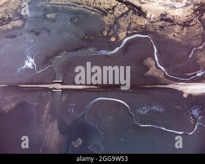 Garve, Schottland, Großbritannien. 30. August 2021.der niedrige Wasserstand im Stausee von Loch Glascarnoch bei Garve hat bisher verborgene Strukturen enthüllt, darunter eine alte Straße, eine Brücke und Telegrafenmasten. Die alte Straße war die Hauptroute von Ullapool nach Dingwall, bis die aktuelle neue Straße neben dem Stausee gebaut wurde. Der Stausee in Glen Glascarnoch wurde in den 1950er Jahren als Teil des Wasserkraftwerks Conon gegründet. Iain Masterton/Alamy Live News. Stockfoto