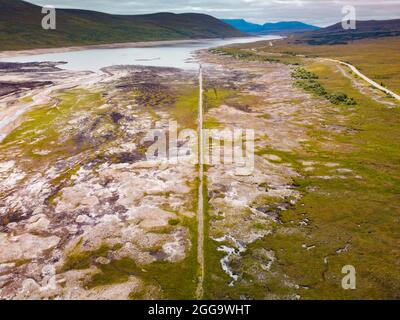 Garve, Schottland, Großbritannien. 30. August 2021.der niedrige Wasserstand im Stausee von Loch Glascarnoch bei Garve hat bisher verborgene Strukturen enthüllt, darunter eine alte Straße, eine Brücke und Telegrafenmasten. Die alte Straße war die Hauptroute von Ullapool nach Dingwall, bis die aktuelle neue Straße neben dem Stausee gebaut wurde. Der Stausee in Glen Glascarnoch wurde in den 1950er Jahren als Teil des Wasserkraftwerks Conon gegründet. Iain Masterton/Alamy Live News. Stockfoto