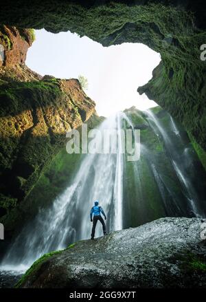 Mann in der Höhle in der Nähe des Gljufrafoss Wasserfalls, Island, Europa. Berühmte Touristenattraktion in der Nähe des Seljalandsfoss Wasserfalls. Landschaftsfotografie Stockfoto