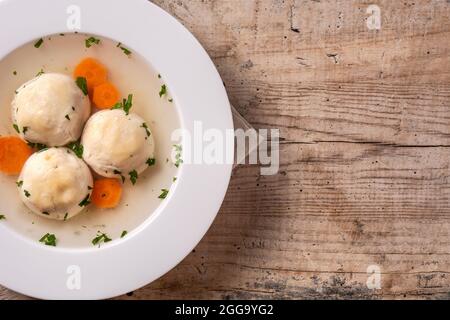 Traditionelle jüdische Matzah-Kugelsuppe auf Holztisch Stockfoto