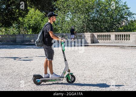 ROM, ITALIEN, GROSSBRITANNIEN. August 2021. Menschen, die in der Villa Borghese an einem heißen Tag in Rom einen Elektroroller fahren. Elektroroller sind in der römischen Hauptstadt populär geworden und werden regelmäßig als Mobilitätstransport eingesetzt. Kredit: amer ghazzal/Alamy Live Nachrichten Stockfoto