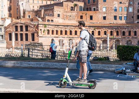 ROM, ITALIEN, GROSSBRITANNIEN. August 2021. Menschen auf einem Elektroroller auf der Via dei Froi Imperiali an einem heißen Tag in Rom. Elektroroller sind in der römischen Hauptstadt populär geworden und werden regelmäßig als Mobilitätstransport eingesetzt. Kredit: amer ghazzal/Alamy Live Nachrichten Stockfoto