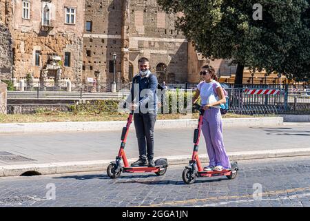 ROM, ITALIEN, GROSSBRITANNIEN. August 2021. Menschen auf einem Elektroroller auf der Via dei Froi Imperiali an einem heißen Tag in Rom. Elektroroller sind in der römischen Hauptstadt populär geworden und werden regelmäßig als Mobilitätstransport eingesetzt. Kredit: amer ghazzal/Alamy Live Nachrichten Stockfoto