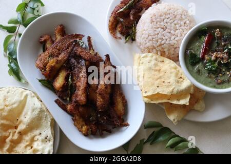 Knusprige und würzige Sardellenbraten. Sardellen mit Gewürzen mariniert und frittiert. Beliebtes Fischgericht aus Kerala genannt Natholi braten. Serviert mit rotem Reis m Stockfoto